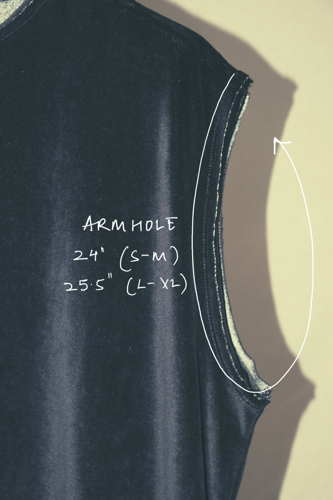 Black sleeveless top with armhole measurements labeled on a beige background